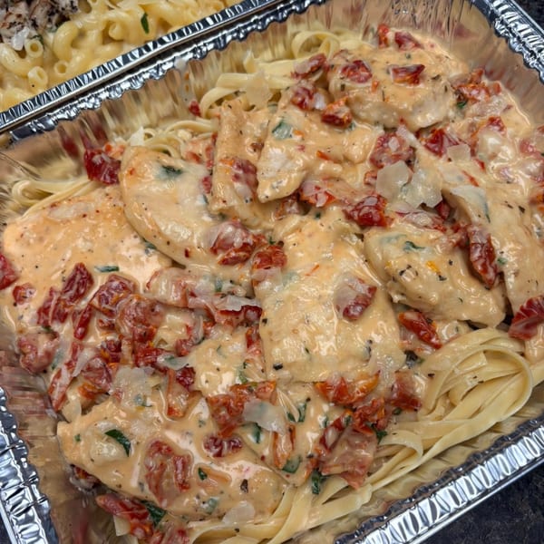 Creamy chicken pasta with sun-dried tomatoes and parmesan in a foil container from Annamarie's on Main.