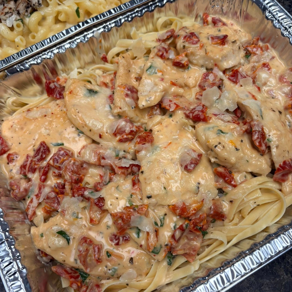 Creamy chicken pasta with sun-dried tomatoes and parmesan in a foil container from Annamarie's on Main.